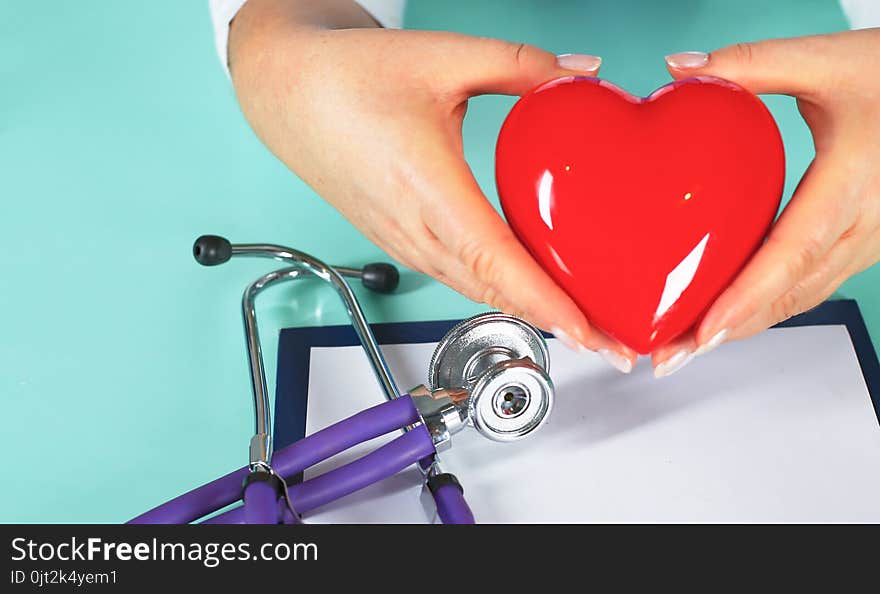 Female Doctor With The Stethoscope Holding Heart