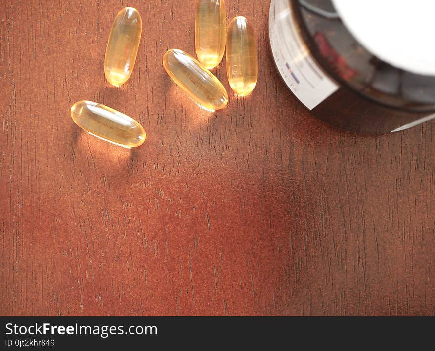 Vitamin Capsules on wood isolated background