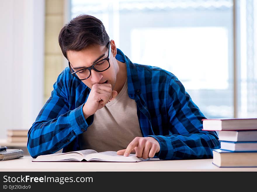 Student studying in the empty library with book preparing for ex