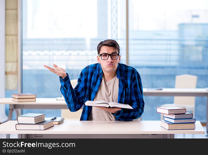 Student studying in the empty library with book preparing for ex