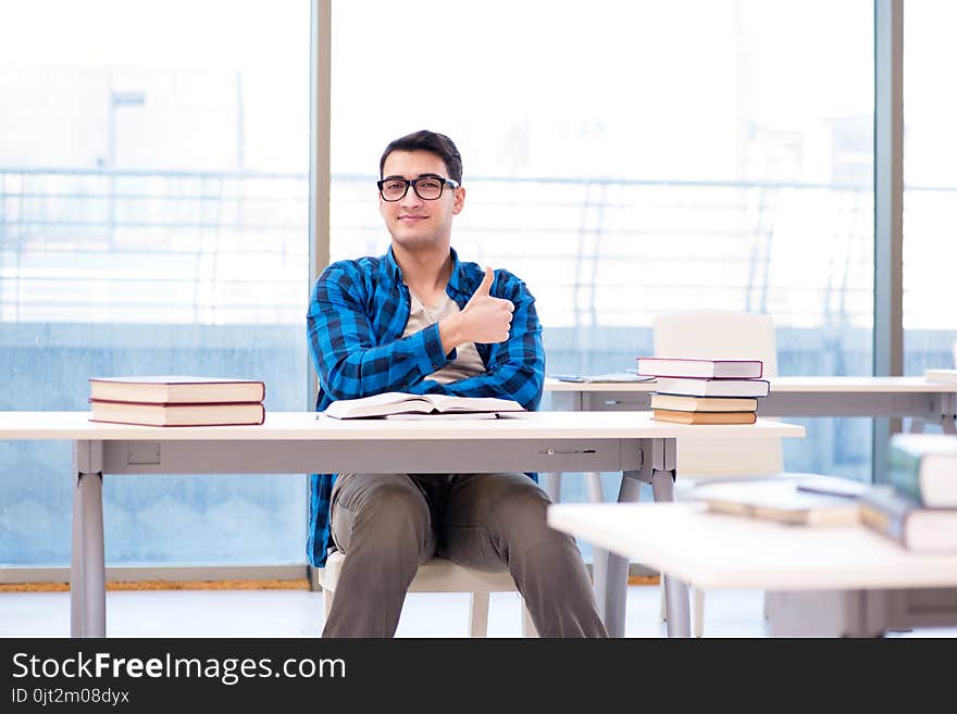 Student studying in the empty library with book preparing for exam