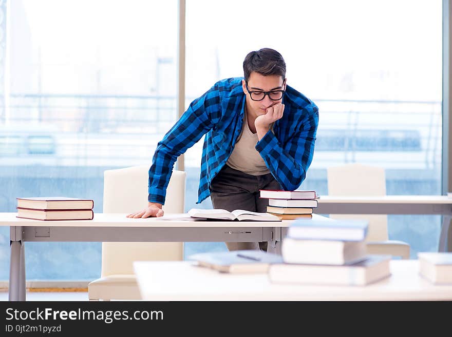 Student studying in the empty library with book preparing for exam