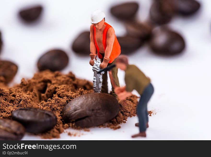 Miniature figures working on coffee macro photography on white background