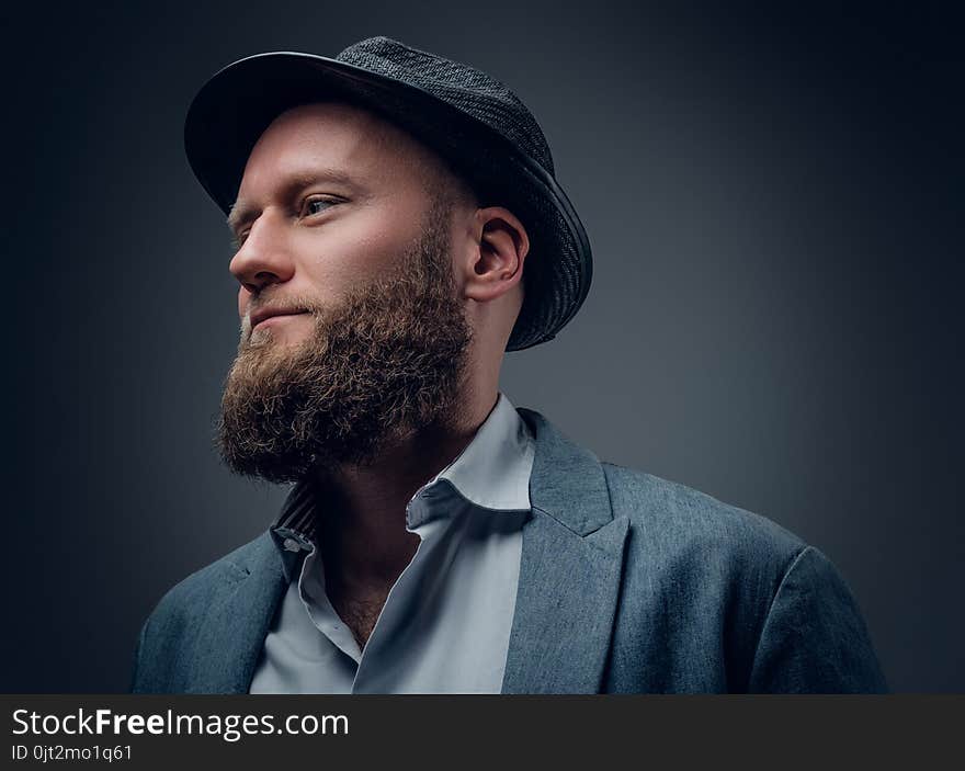 Close up studio portrait of bearded male in a felt hat on grey background. Close up studio portrait of bearded male in a felt hat on grey background.