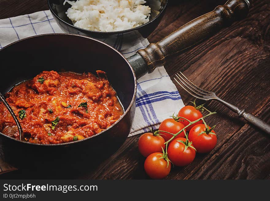 Traditional indian cuisine. Spicy tikka masala with rice on wood table. Traditional indian cuisine. Spicy tikka masala with rice on wood table