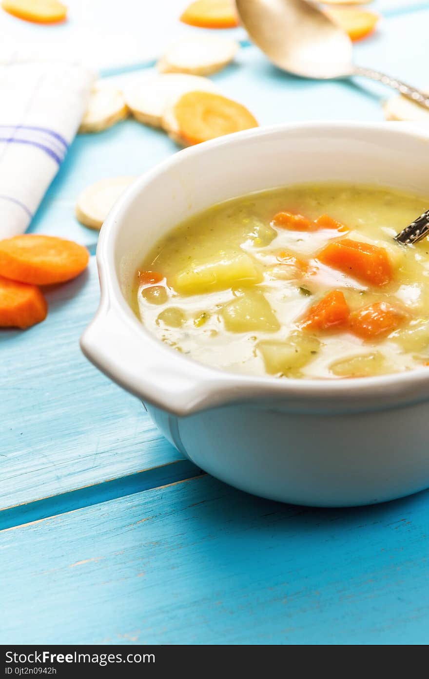 Homemade vegetables with carrot soup on blue wood table. Homemade vegetables with carrot soup on blue wood table