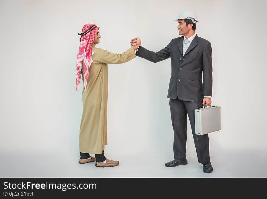 Arab businessman and foreman worker handshaking, men