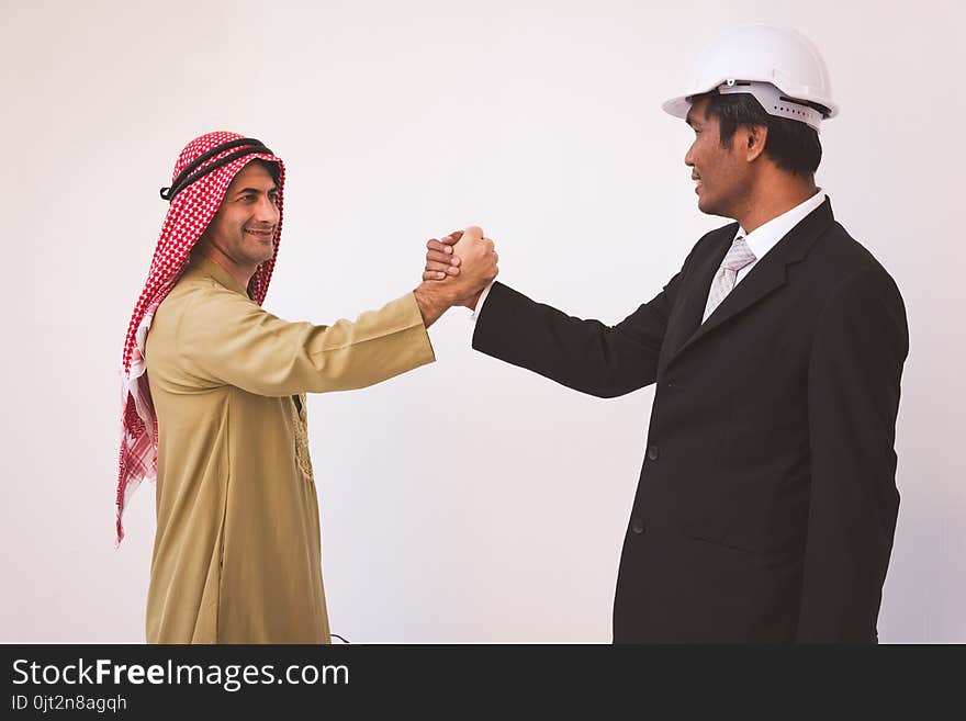 Arab businessman and foreman worker handshaking, USA