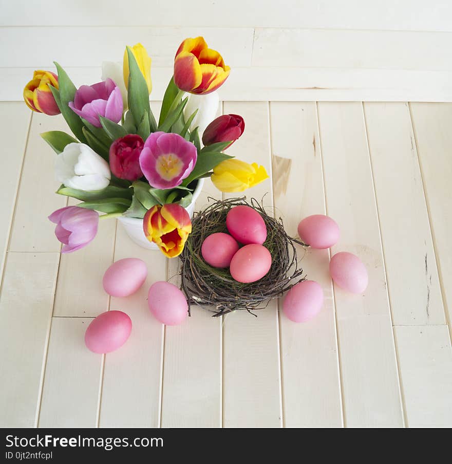 Easter. Pink easter eggs and tulips lie on a wooden background. Flat lay.