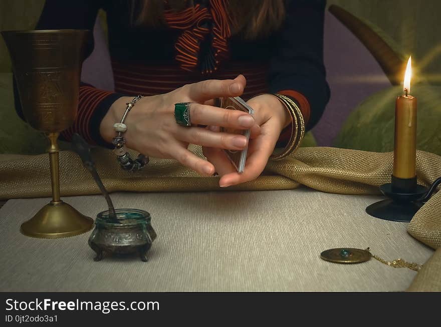 Tarot cards on fortune teller desk table. Future reading. Woman fortune teller holding in hands a deck of tarot cards and shuffles it. Tarot cards on fortune teller desk table. Future reading. Woman fortune teller holding in hands a deck of tarot cards and shuffles it.