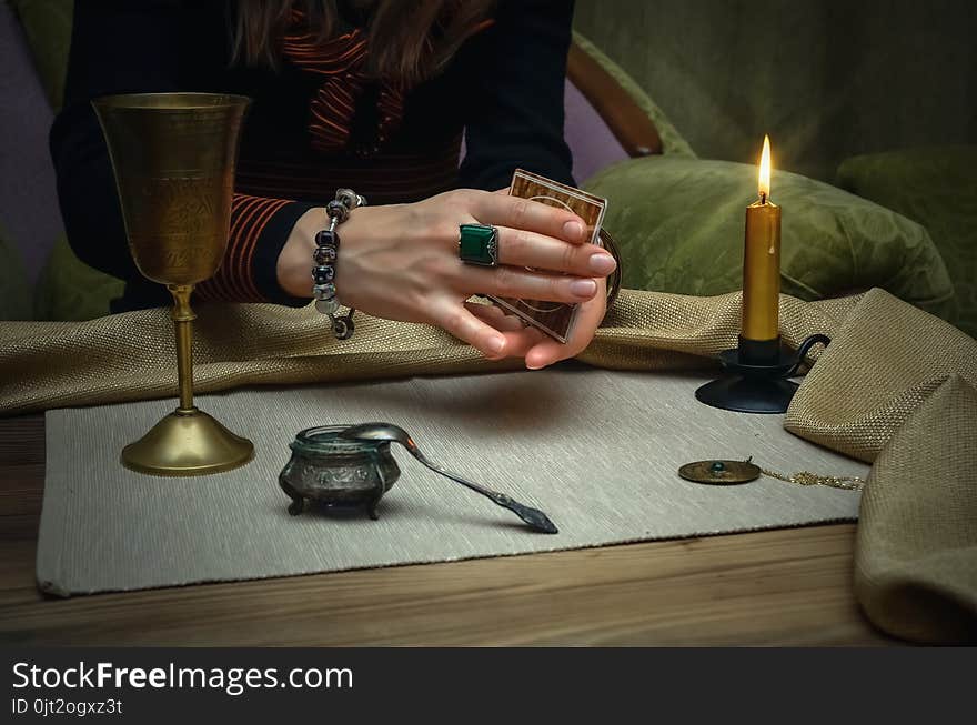 Tarot cards on fortune teller desk table. Future reading. Woman fortune teller holding in hands a deck of tarot cards and shuffles it. Tarot cards on fortune teller desk table. Future reading. Woman fortune teller holding in hands a deck of tarot cards and shuffles it.