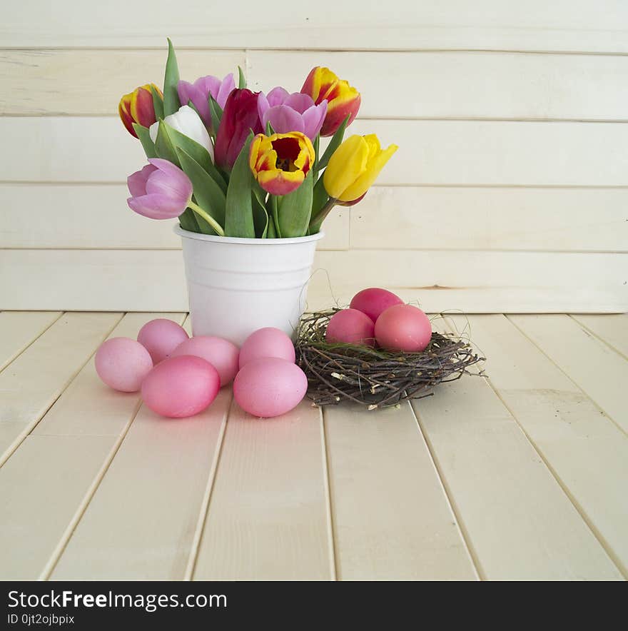 Easter. Pink easter eggs and tulips lie on a wooden background. Flat lay.