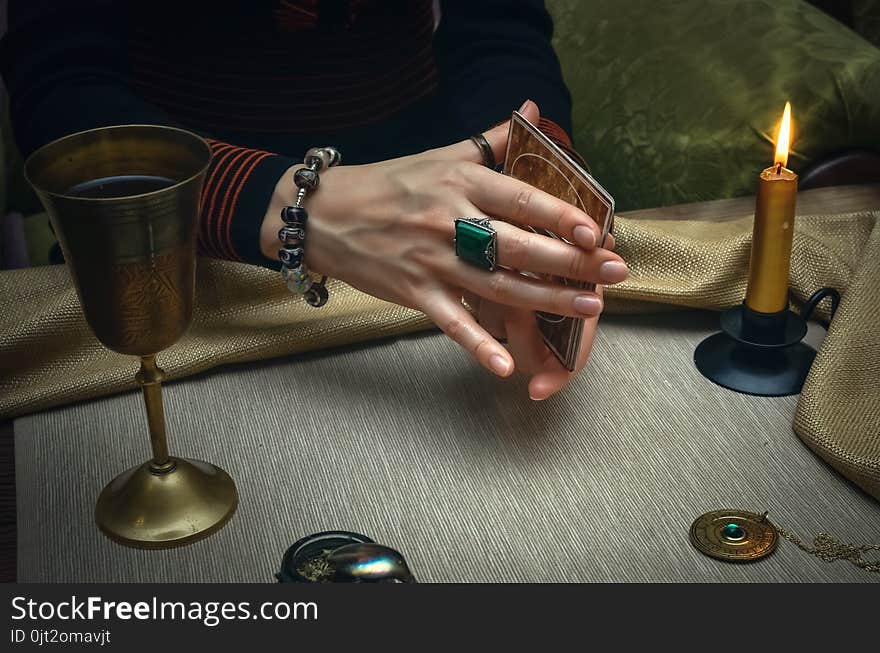 Tarot cards on fortune teller desk table. Future reading. Woman fortune teller holding in hands a deck of tarot cards and shuffles it. Tarot cards on fortune teller desk table. Future reading. Woman fortune teller holding in hands a deck of tarot cards and shuffles it.