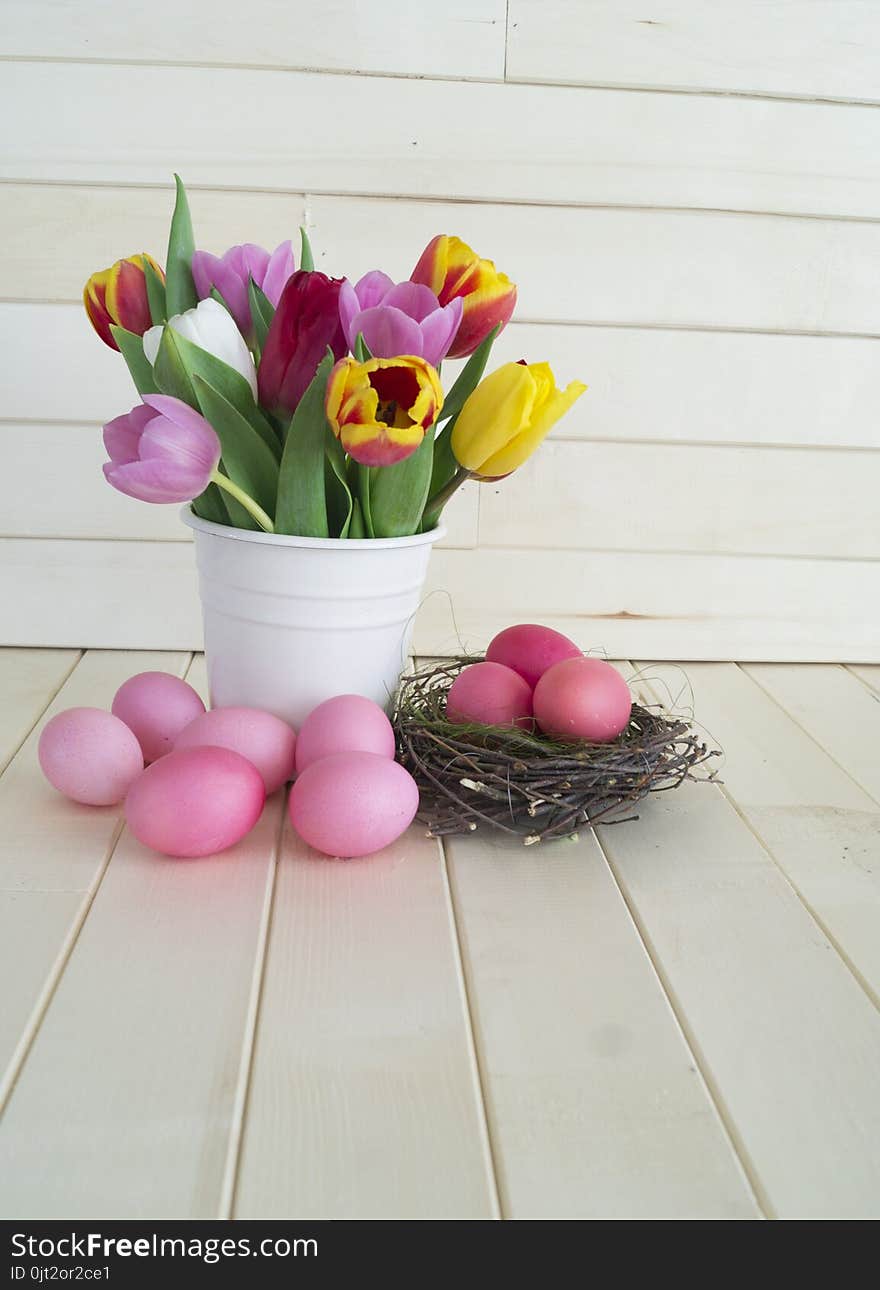 Easter. Pink Easter Eggs And Tulips Lie On A Wooden Background. Flat Lay.