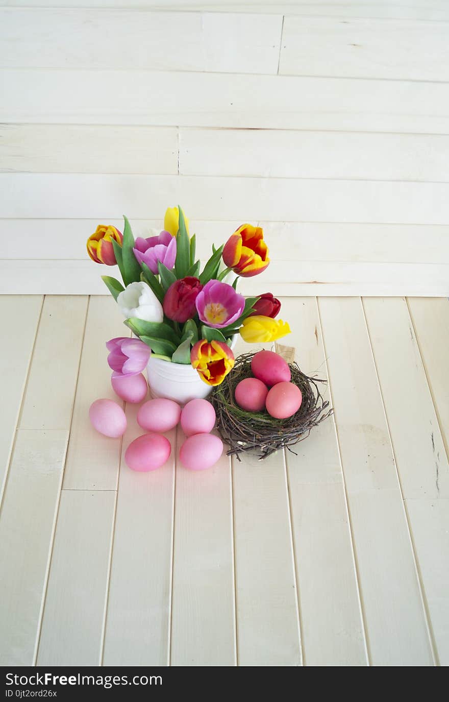 Easter. Pink easter eggs and tulips lie on a wooden background. Flat lay.