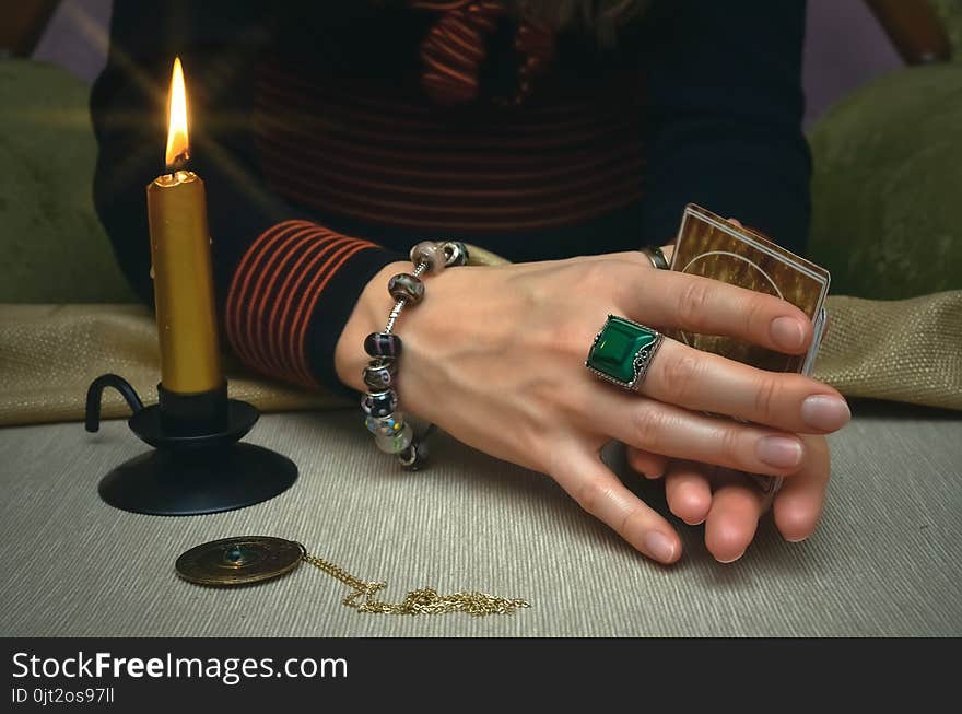 Tarot cards on fortune teller desk table. Future reading. Woman fortune teller holding in hands a deck of tarot cards and shuffles it. Tarot cards on fortune teller desk table. Future reading. Woman fortune teller holding in hands a deck of tarot cards and shuffles it.