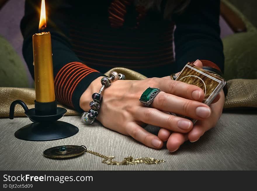 Tarot cards on fortune teller desk table. Future reading. Woman fortune teller holding in hands a deck of tarot cards and shuffles it. Tarot cards on fortune teller desk table. Future reading. Woman fortune teller holding in hands a deck of tarot cards and shuffles it.