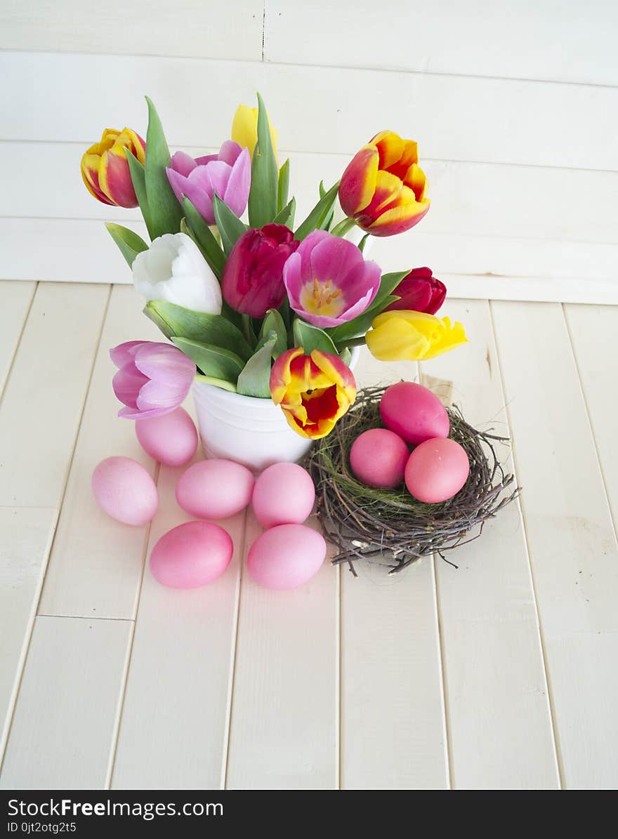 Easter. Pink Easter Eggs And Tulips Lie On A Wooden Background. Flat Lay.