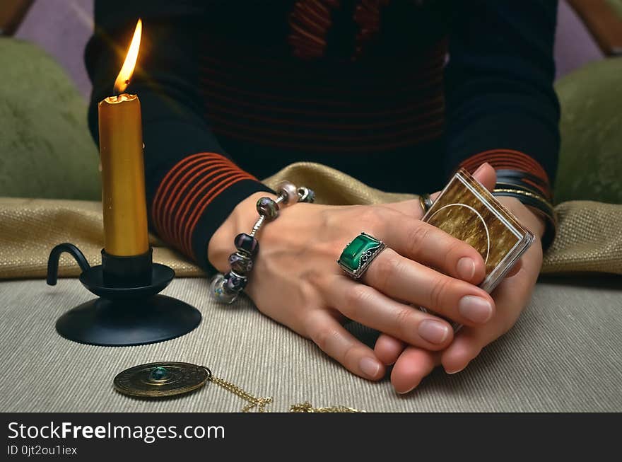 Tarot cards on fortune teller desk table. Future reading. Woman fortune teller holding in hands a deck of tarot cards and shuffles it. Tarot cards on fortune teller desk table. Future reading. Woman fortune teller holding in hands a deck of tarot cards and shuffles it.