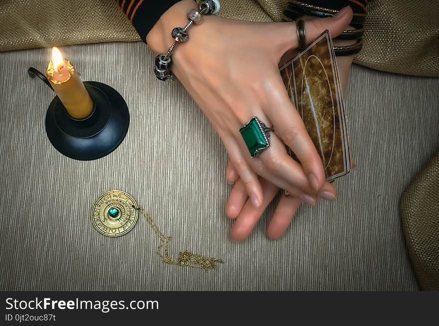 Tarot cards on fortune teller desk table. Future reading. Woman fortune teller holding in hands a deck of tarot cards and shuffles it. Tarot cards on fortune teller desk table. Future reading. Woman fortune teller holding in hands a deck of tarot cards and shuffles it.