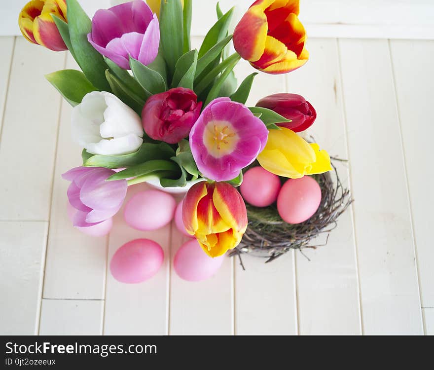 Easter. Pink Easter Eggs And Tulips Lie On A Wooden Background. Flat Lay.