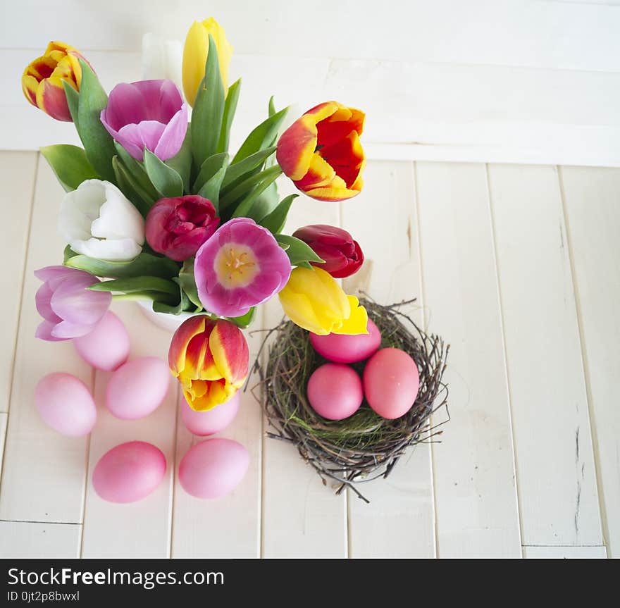 Easter. Pink Easter Eggs And Tulips Lie On A Wooden Background. Flat Lay.