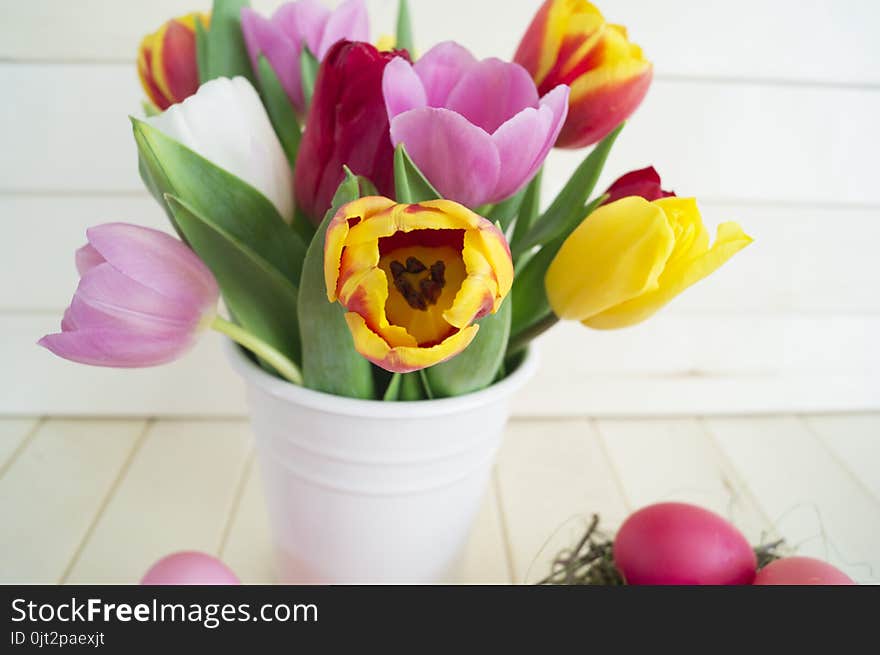 Easter. Pink easter eggs and tulips lie on a wooden background. Flat lay.