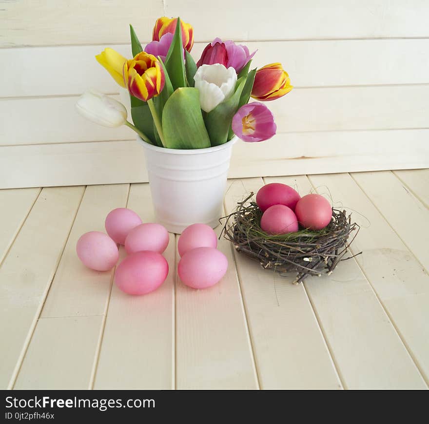 Easter. Pink easter eggs and tulips lie on a wooden background. Flat lay. Bird`s Nest. March 8. Pastel shades of pink. Wooden background. Conceptual photo. St. Patrick`s Day. Easter pink rabbit.