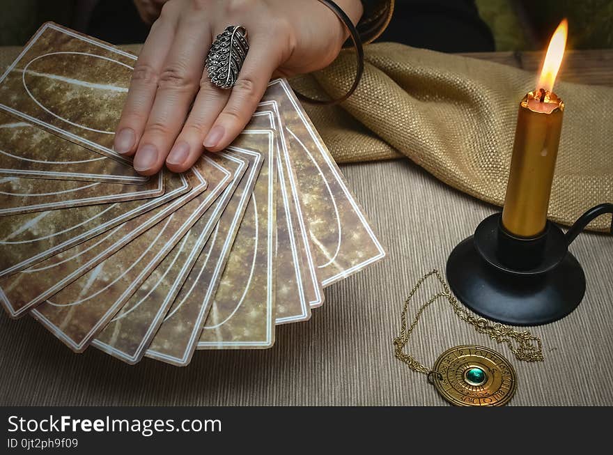 Tarot cards on fortune teller desk table. Future reading. Woman fortune teller holding in hands a deck of tarot cards. Tarot cards on fortune teller desk table. Future reading. Woman fortune teller holding in hands a deck of tarot cards.