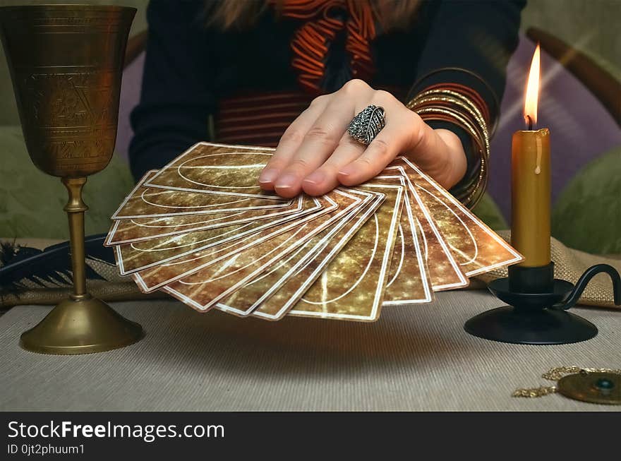 Tarot cards on fortune teller desk table. Future reading. Woman fortune teller holding in hands a deck of tarot cards. Tarot cards on fortune teller desk table. Future reading. Woman fortune teller holding in hands a deck of tarot cards.