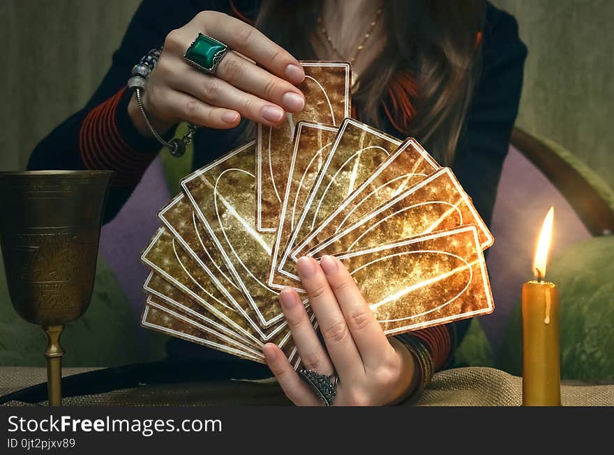 Tarot cards on fortune teller desk table. Future reading. Woman fortune teller holding and hands a deck of tarot cards and shuffles it. Tarot cards on fortune teller desk table. Future reading. Woman fortune teller holding and hands a deck of tarot cards and shuffles it.