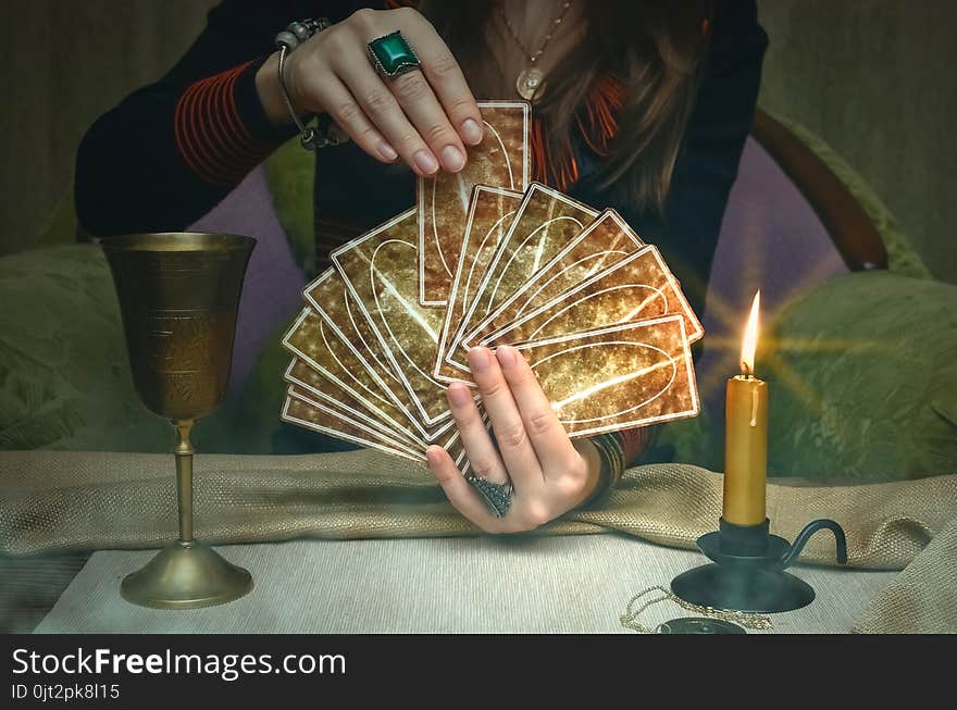 Tarot cards on fortune teller desk table. Future reading. Woman fortune teller holding and hands a deck of tarot cards. Tarot cards on fortune teller desk table. Future reading. Woman fortune teller holding and hands a deck of tarot cards.