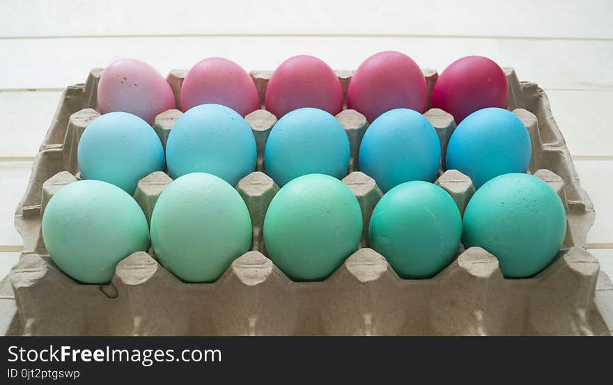 Easter.Pastel colored eggs.Spring composition.Flat ley.Many Easter eggs lie in a container for eggs. Curly eggs.Handmade.Wooden background. Basket woven