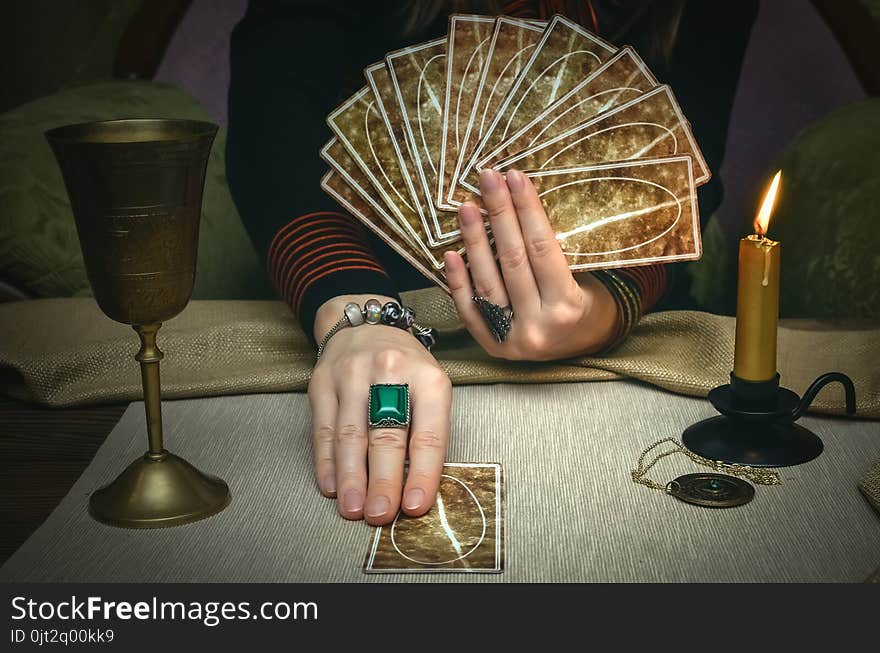 Tarot cards on fortune teller desk table. Future reading. Woman fortune teller holding and hands a deck of tarot cards. Tarot cards on fortune teller desk table. Future reading. Woman fortune teller holding and hands a deck of tarot cards.