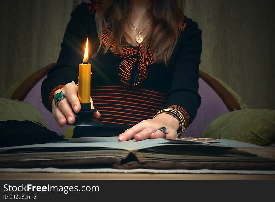 Tarot cards on fortune teller desk table. Future reading. Woman witch reads a ancient magic scroll book and learn art of prediction on wooden table. Tarot cards on fortune teller desk table. Future reading. Woman witch reads a ancient magic scroll book and learn art of prediction on wooden table.