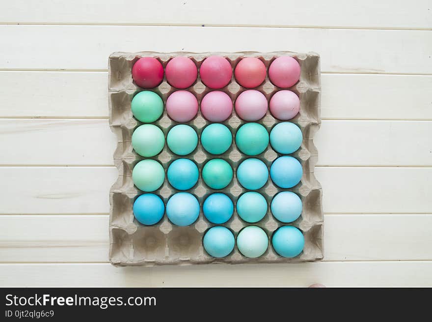 Easter.Pastel colored eggs.Spring composition.Flat ley.Many Easter eggs lie in a container for eggs. Curly eggs.Handmade.Wooden background. Basket woven