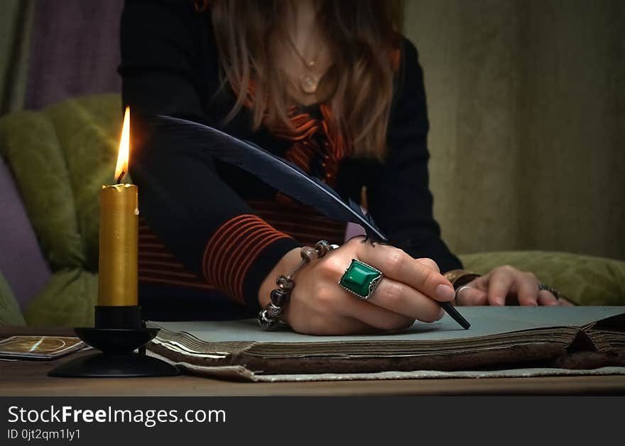 Tarot cards on fortune teller desk table. Future reading. Woman witch writes a magic scroll book with feather pen. Author. Tarot cards on fortune teller desk table. Future reading. Woman witch writes a magic scroll book with feather pen. Author.