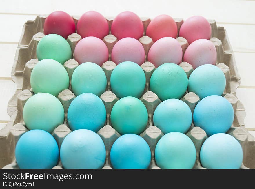 Easter.Pastel colored eggs.Spring composition.Flat ley.Many Easter eggs lie in a container for eggs. Curly eggs.Handmade.Wooden background. Basket woven