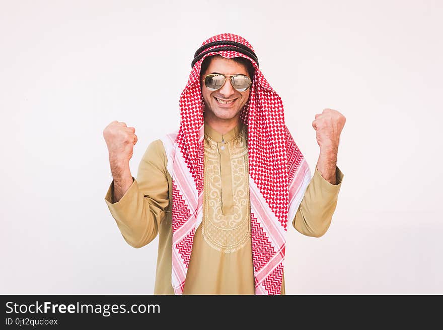 Happy young Arab businessman with hands up.