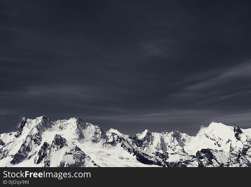 Winter snowy mountains in cold sunny day. Caucasus Mountains, region Dombay. Black and white. Toned landscape.