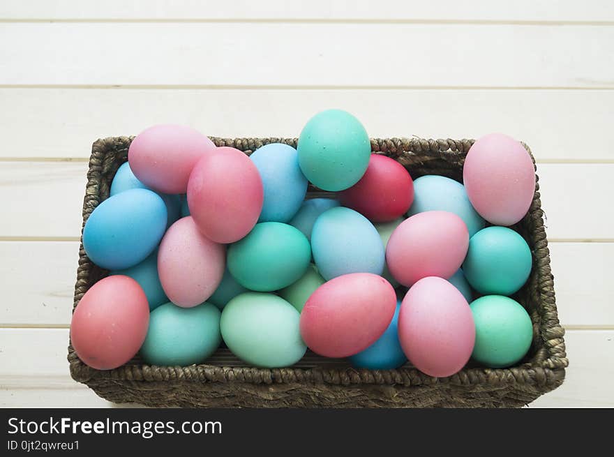 Easter.Pastel colored eggs.Spring composition.Flat ley.Many Easter eggs lie in a container for eggs. Curly eggs.Handmade.Wooden background. Basket woven