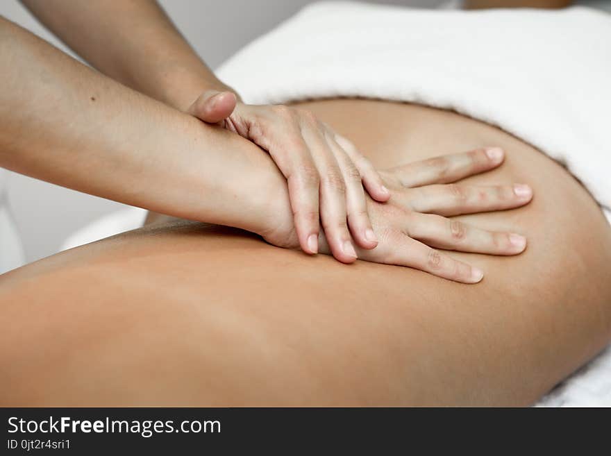 Young woman receiving a back massage in a spa center.