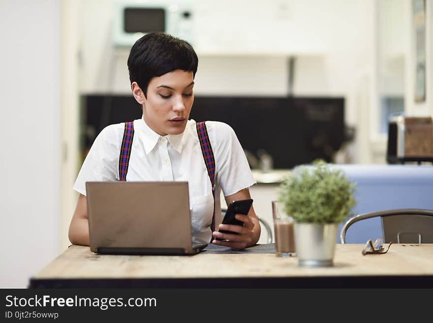 Young Businesswoman With Very Short Haircut Looking At Her Smart