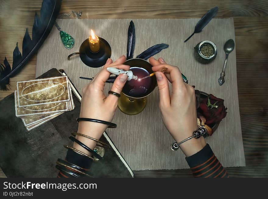 Woman witch prepare a magic potion. Future reading. Tarot cards on fortune teller desk table. Woman witch prepare a magic potion. Future reading. Tarot cards on fortune teller desk table.