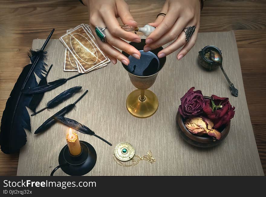 Woman witch prepare a magic potion. Future reading. Tarot cards on fortune teller desk table. Woman witch prepare a magic potion. Future reading. Tarot cards on fortune teller desk table.