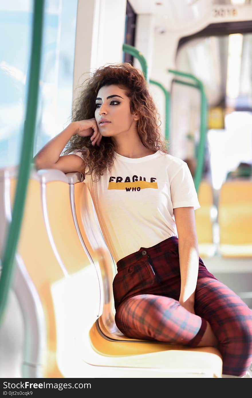 Arabic woman sitting inside subway train. Arab girl in casual clothes near a window. Arabic woman sitting inside subway train. Arab girl in casual clothes near a window.