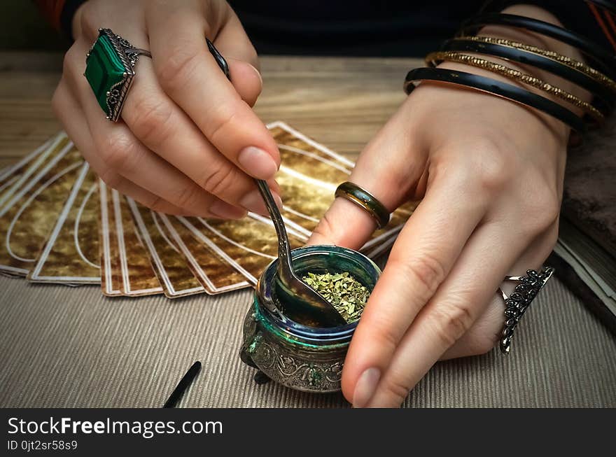 Woman witch prepare a magic potion. Future reading. Tarot cards on fortune teller desk table. Woman witch prepare a magic potion. Future reading. Tarot cards on fortune teller desk table.