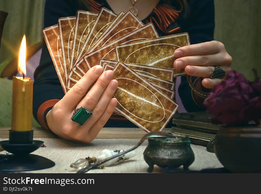 Tarot cards on fortune teller desk table. Future reading. Woman fortune teller holding in hands a deck of tarot cards. Tarot cards on fortune teller desk table. Future reading. Woman fortune teller holding in hands a deck of tarot cards.