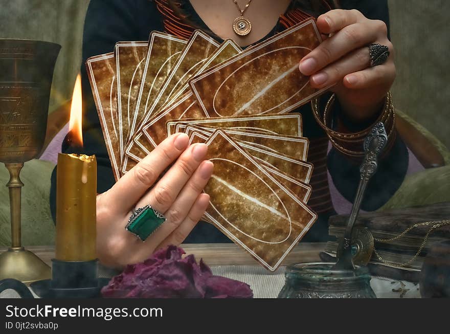 Tarot cards on fortune teller desk table. Future reading. Woman fortune teller holding in hands a deck of tarot cards. Tarot cards on fortune teller desk table. Future reading. Woman fortune teller holding in hands a deck of tarot cards.