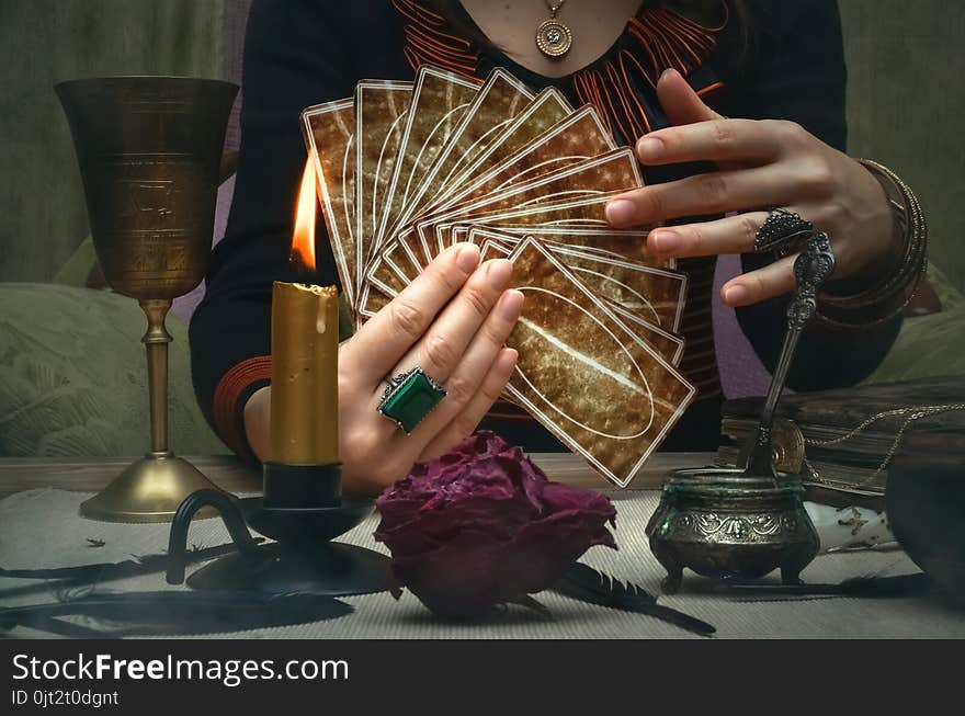 Tarot cards on fortune teller desk table. Future reading. Woman fortune teller holding and hands a deck of tarot cards. Tarot cards on fortune teller desk table. Future reading. Woman fortune teller holding and hands a deck of tarot cards.